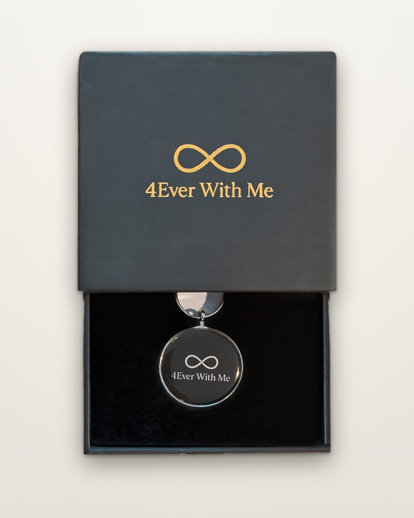 The 4Ever With Me memorial keychain in its black gift box with gold foil logo